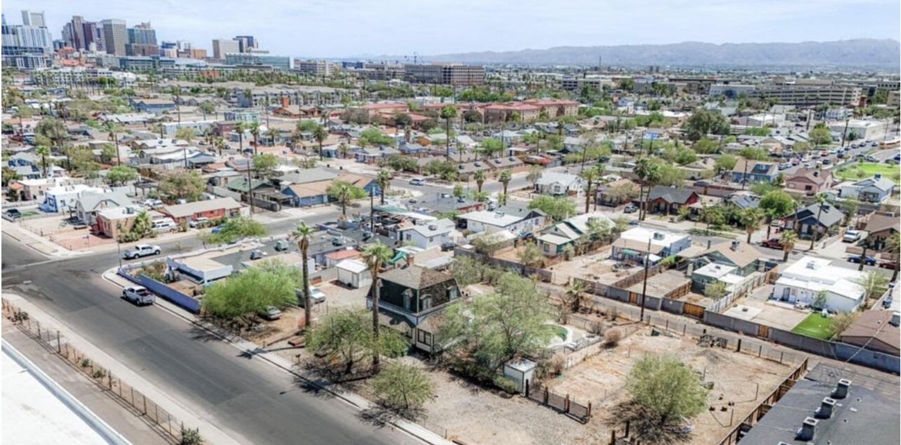 Aerial view of Oakland's historic rooftops with the downtown Phoenix skyline beyond