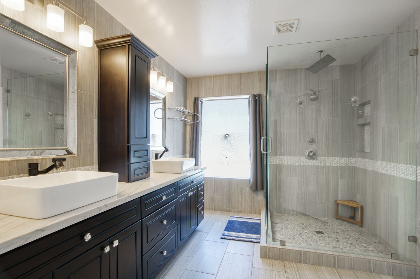 Primary bathroom with dual vessel sinks and walk-in glass shower at 15968 W Jefferson Street